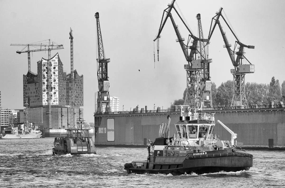 Ein Schlepper im Hamburger Hafen vor dem Schwimmdock, dahinter die Elbphilharmonie im Bau